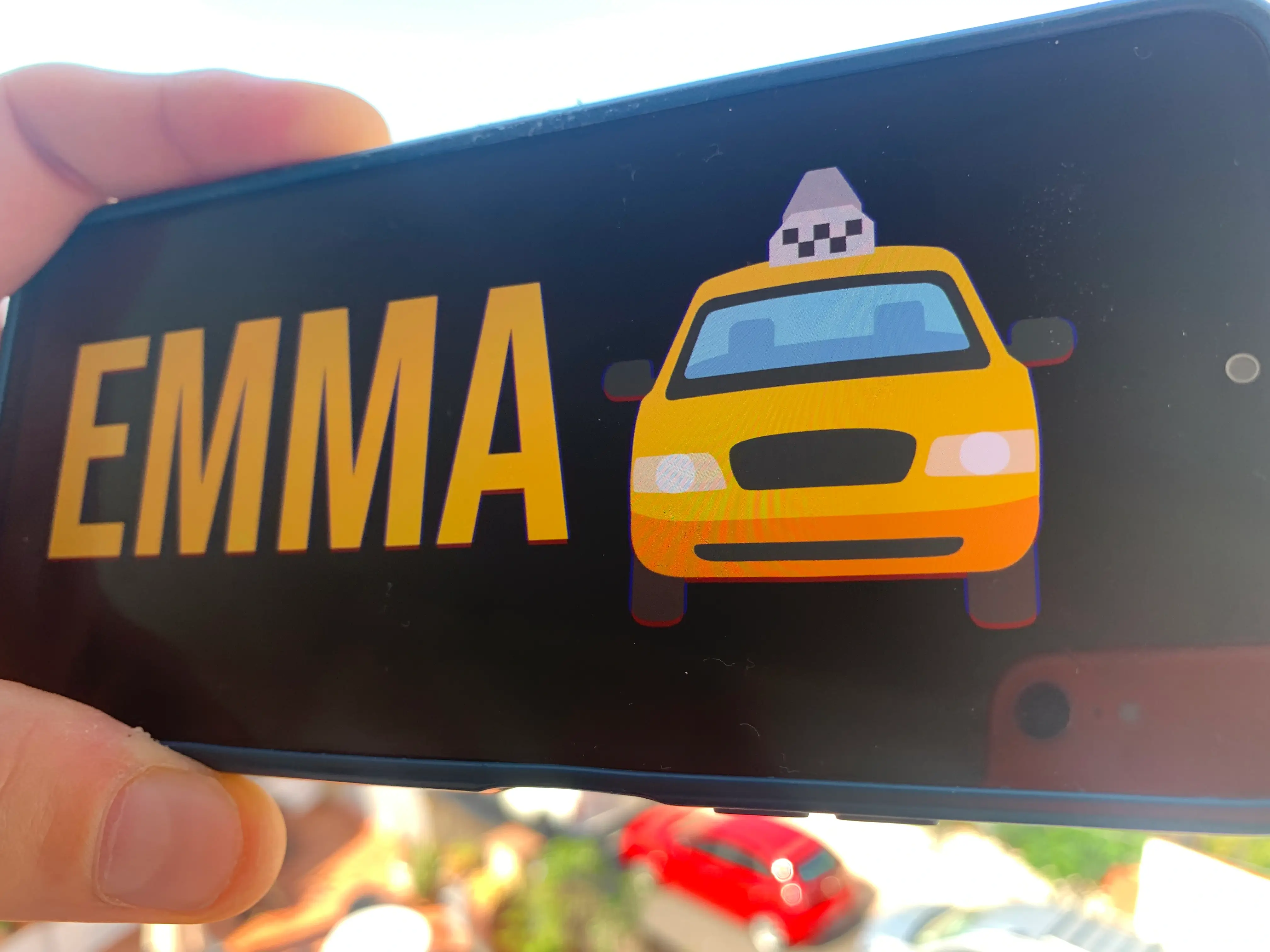 Phone showing a simple airport pickup name sign with the message Emma